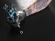 Los mejores tatuadores en CDMX - Mano de un tatuador sosteniendo una máquina de tatuar, la cual va a sumergir en tinta para empezar el tatuaje en CDMX