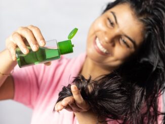 Remedios naturales para el cabello - Mujer aplicándose remedios para la caída del cabello e hidratar el pelo seco