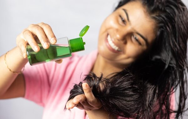 Remedios naturales para el cabello - Mujer aplicándose remedios para la caída del cabello e hidratar el pelo seco