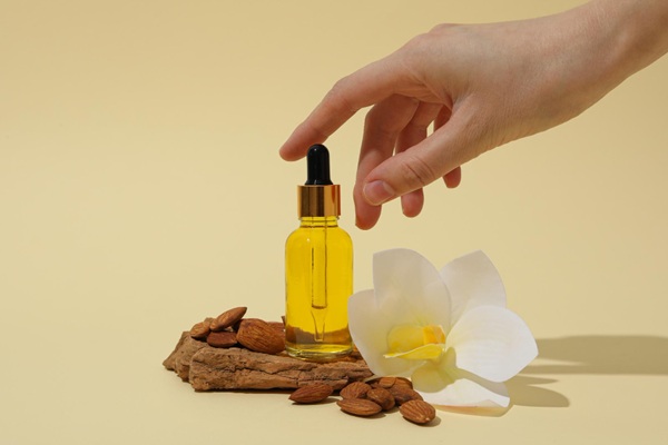 Recipiente con aceite de almendras que hidrata la fibra capilar para detener la caída del cabello