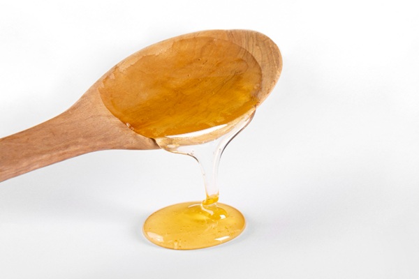 Remedios naturales para el cabello - Cuchara con miel de abeja uno de los mejores remedios para la caída del cabello que ayuda a hidratar el pelo seco