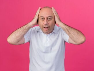 Soluciones a la calvicie - Hombre con las manos en la cabeza pensando en las soluciones a la calvicie
