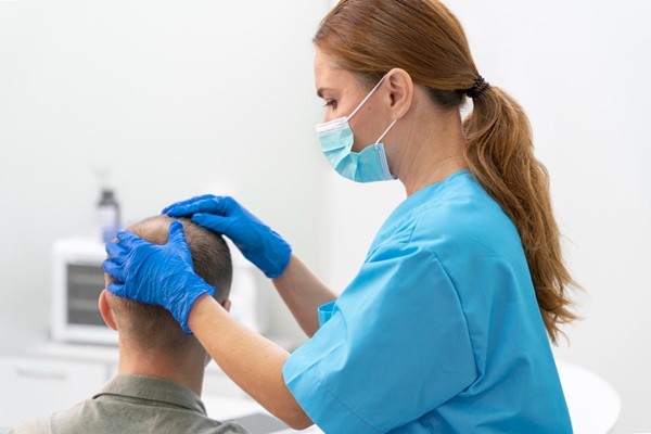 Médico tricólogo evaluando el cuero cabelludo de un hombre con alopecia antes de un injerto capilar CDMX
