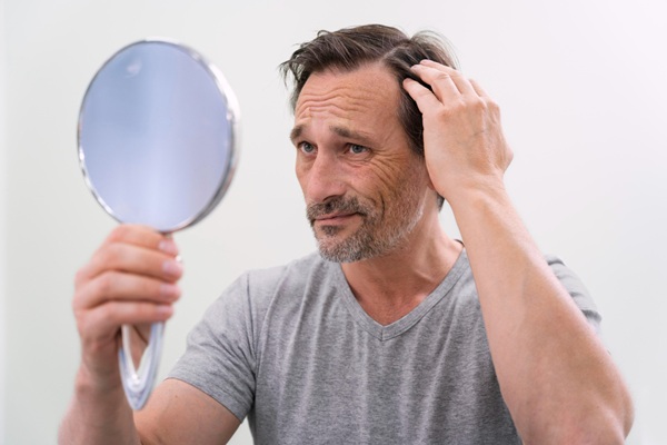 Trasplante de cabello - Hombre triste observando el avance de la pérdida de cabello antes de realizarse un implante capilar CDMX