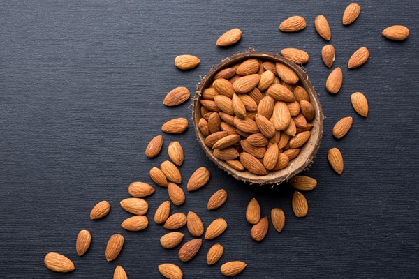 Semillas para el pelo - Recipiente con almendras una fuente importante de biotina para fortalecer el cabello