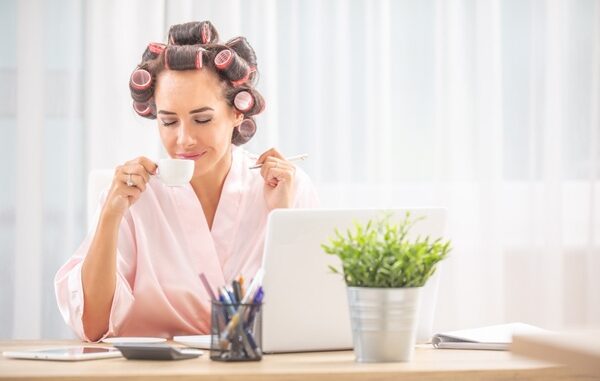 Blogs de cuidado capilar - Mujer relajada usando una computadora para leer noticias digitales sobre el cuidado del cabello en México