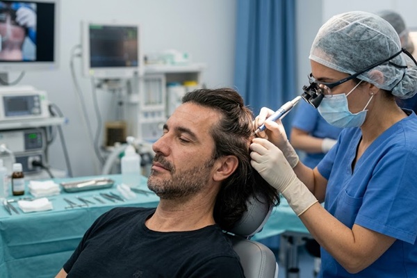 Cirujana realizando un implante cabello con la técnica Long Hair FUE sin rapar el cabello de la zona donante